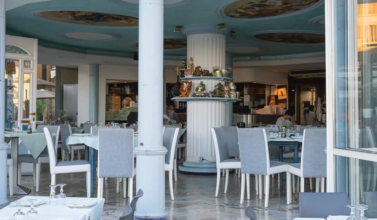 Elegante interno del ristorante con colonne bianche, soffitto affrescato e tavoli apparecchiati.